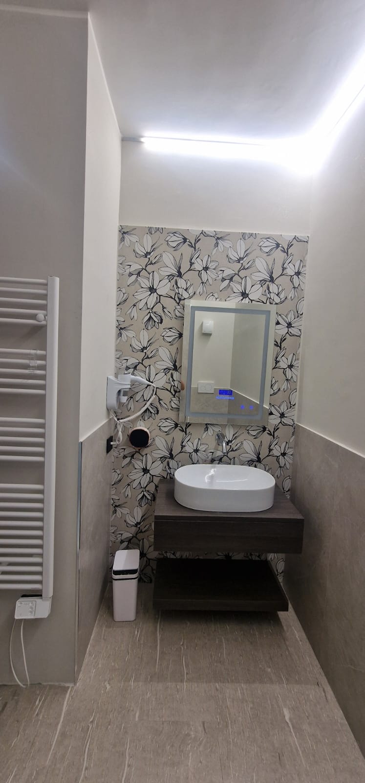 Bagno con specchio LED e carta da parati floreale